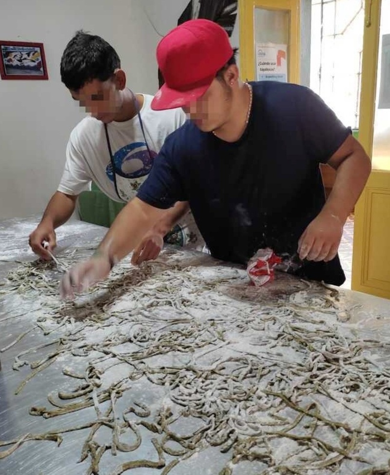 Jóvenes cortando los tallarines