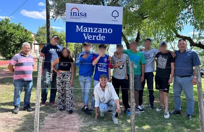 Educadores, adolescentes y directora Pérez en el cartel del centro