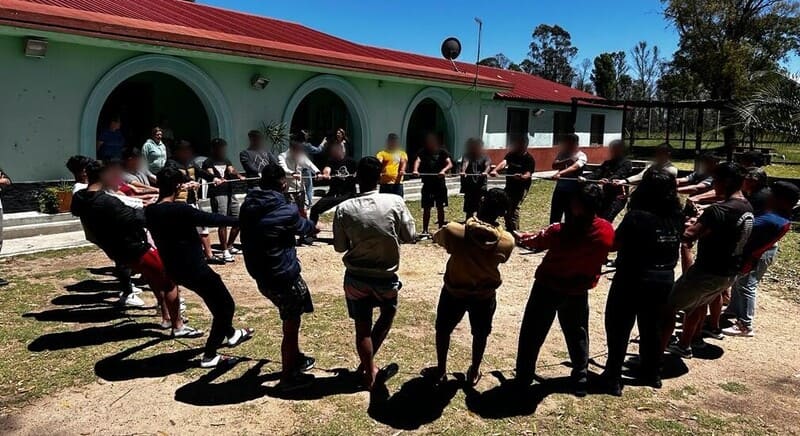 Jóvenes agarrados de una cuerda en círculo.