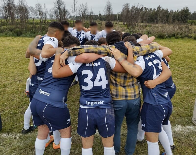Jóvenes formando un círculo hablando antes del partido